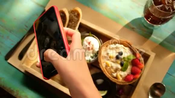 女人用智能手机拍照食物视频的预览图