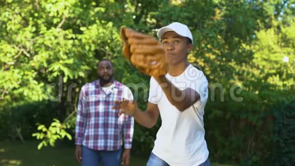 快乐的父亲赞扬儿子在公园打棒球家庭支持联系视频的预览图