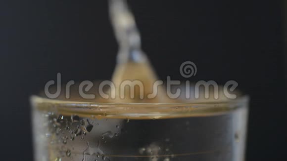阿司匹林或泡腾药片滴在黑底的一杯水中视频的预览图