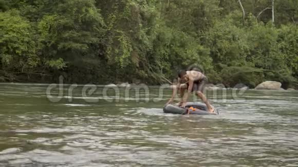 一个土著男孩在水中玩浮胎视频的预览图