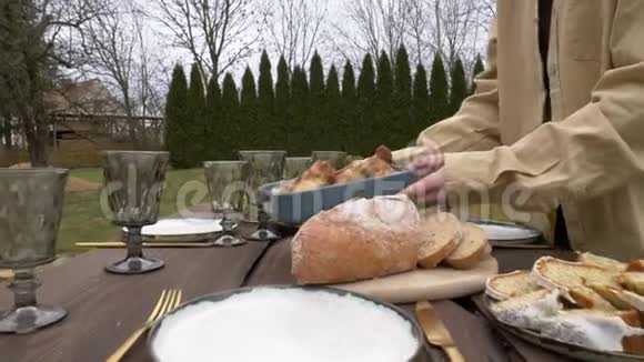 女人把食物放在后院的桌子上视频的预览图