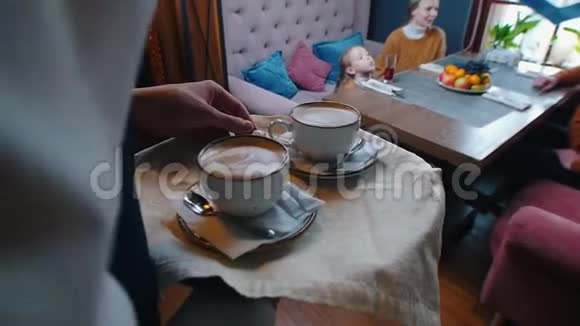 一个成功的家庭坐在酒店的餐馆里一个侍者把咖啡带到桌子上视频的预览图
