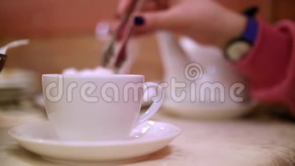 女人的手紧紧地把一块苏格放进碗茶里喝茶仪式视频的预览图