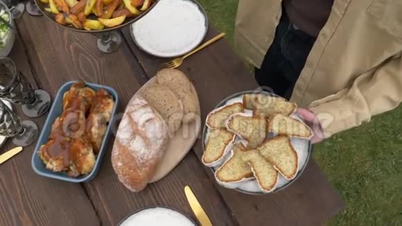 女人把食物放在后院的桌子上视频的预览图