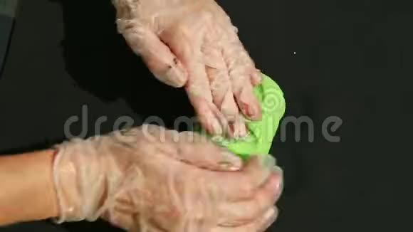 女性手上的俯视图揉捏一大块亮绿色的杏仁糖视频的预览图
