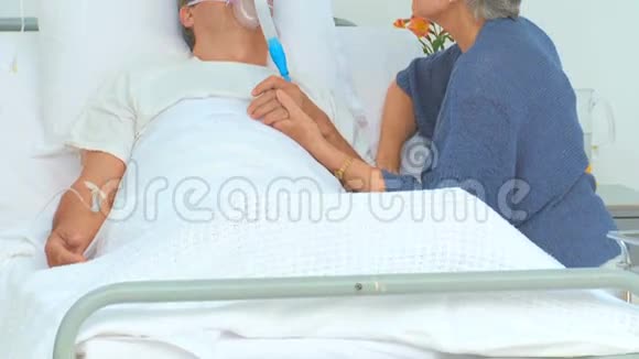 一位老年妇女与昏迷的丈夫交谈视频的预览图