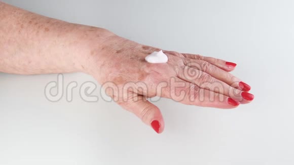 快乐的老年妇女使用手霜保持皮肤健康视频的预览图