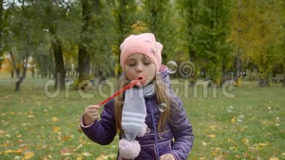 秋天公园吹肥皂泡的小女孩视频的预览图