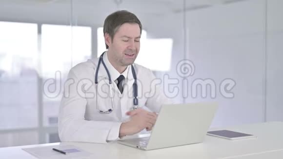快乐中老年医生在笔记本电脑上进行视频聊天视频的预览图