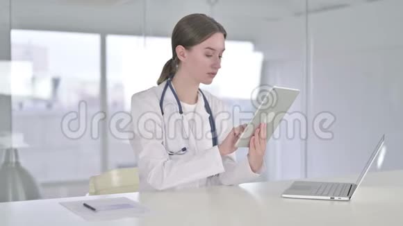 现代办公室中使用平板电脑的勤劳年轻女医生视频的预览图