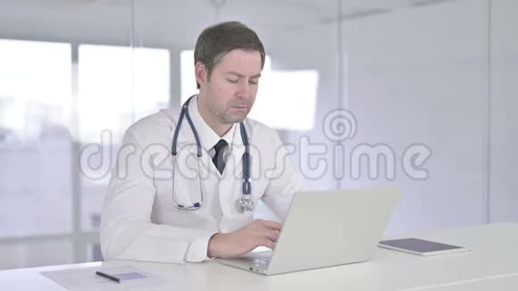 专注中老年医生手提电脑视频的预览图