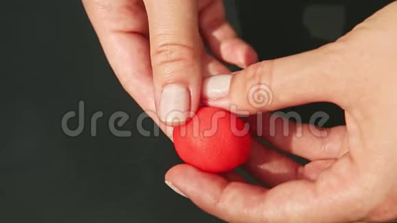 从一块红色的杏仁糖上可以看到女人手上的草莓形状视频的预览图