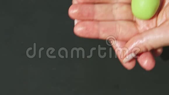 俯视图特写女性手卷出小圆片绿色杏仁糖视频的预览图