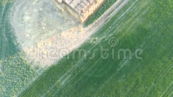 两片田之间干草堆上方飞行的俯视空中视频视频的预览图