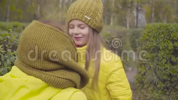 一个笑容满面的白人女孩和妈妈玩女人和女儿穿着类似的黄色外套和芥末视频的预览图
