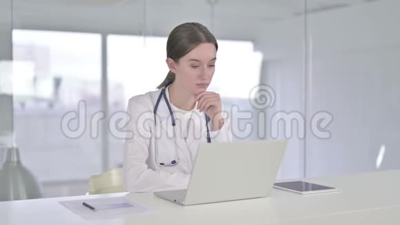 年轻女医生在办公室里思考和工作笔记本电脑视频的预览图
