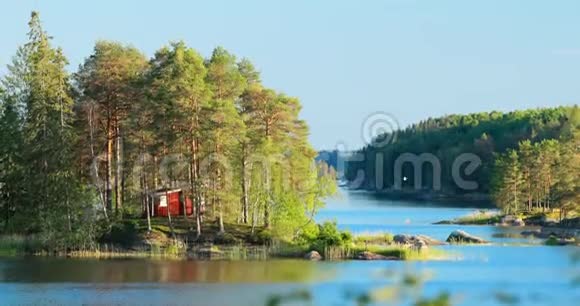 瑞典美丽的红色瑞典木制木屋在落基岛海岸在夏季阳光的夜晚或河流视频的预览图