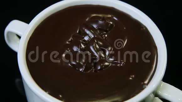 顶部特写融化的黑巧克力放在大白杯中视频的预览图