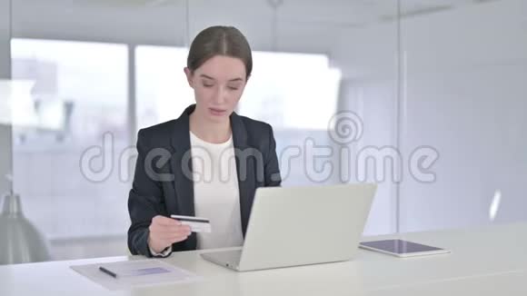 年轻女商人在笔记本电脑上庆祝网上支付成功视频的预览图
