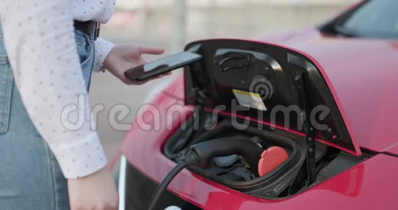电动汽车插座拉到焦点同时充电环保汽车女孩把电源插上视频的预览图