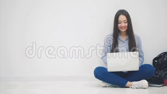 可爱的亚洲小姐坐在地板上以洛托斯的姿势在网上搜索用一只手捂住她的嘴视频的预览图