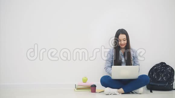 一位亚洲女士坐在地板上坐在洛托斯的位置上拿着笔记本电脑举起双手指着一件非常重要的东西视频的预览图