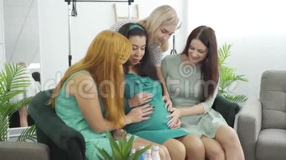 年轻微笑的白种人女孩抚摸着肚子的准女人可爱的女人花时间陪怀孕视频的预览图