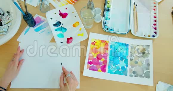 用画笔在纸上描画女人的手水彩画创作过程视频的预览图