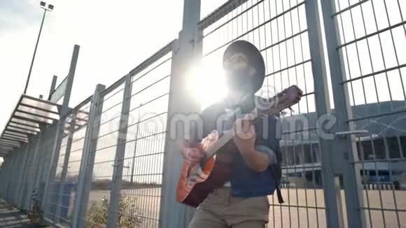 年轻人走在夕阳下弹吉他自由概念视频的预览图
