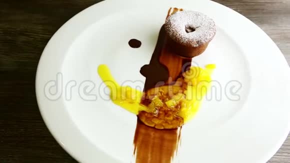 在糖粉巧克力蛋糕上放大在盘子上旋转视频的预览图