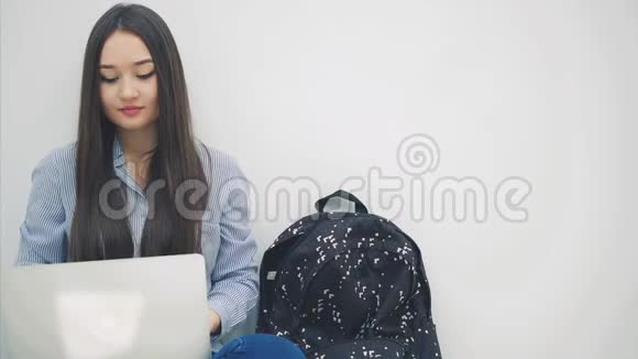 可爱的年轻亚洲女士坐在地板上的洛托斯位置手提电脑放弃拇指摆姿势视频的预览图