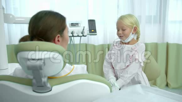 女孩坐在牙医椅上与牙医交谈视频的预览图