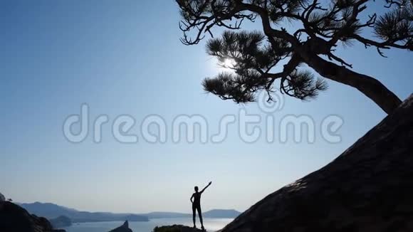 征服山顶的那个年轻女孩举起了手紧握着拳头作为岩石的标志视频的预览图