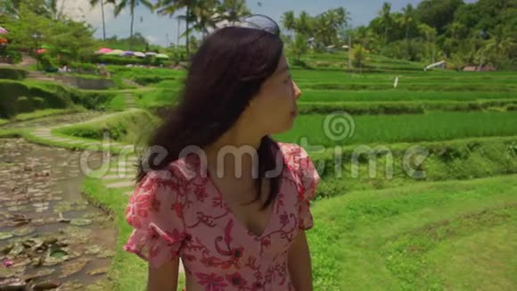 慢动作户外生活方式拍摄于年轻美丽快乐的亚洲女性穿着时尚的夏装漫步稻田视频的预览图