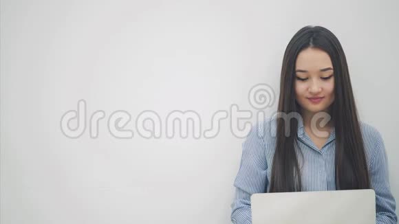 令人惊讶的亚洲女士坐在地板上拿着笔记本电脑用一双惊讶的手捂住嘴视频的预览图