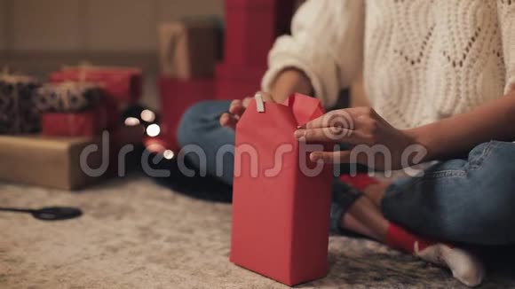 在舒适的家庭背景下女孩的双手准备礼物最后包装礼物圣诞节和新的视频的预览图