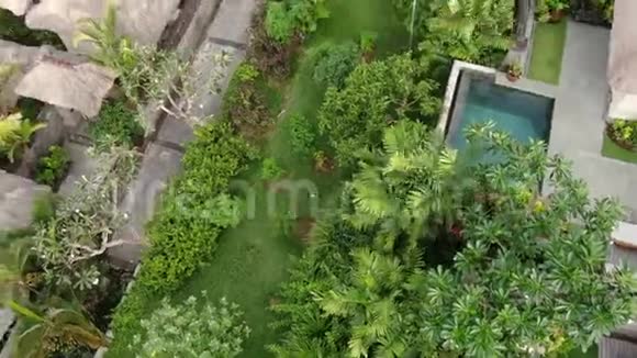 一架无人机飞过海滨的一个热带小屋村庄视频的预览图