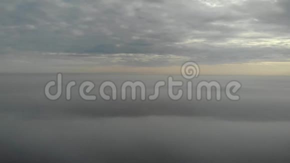 在云层上空飞行凌晨无人机拍摄的视频城市上空的烟雾环顾全景实时时间视频的预览图