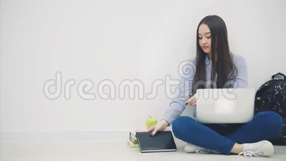 可爱的亚洲小姐坐在莲花的位置上拿着笔记本电脑手指着相机然后走向视频的预览图