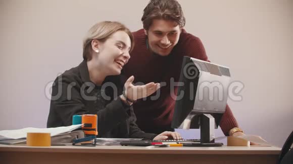办公室一个男人在帮一个女人处理电脑视频的预览图