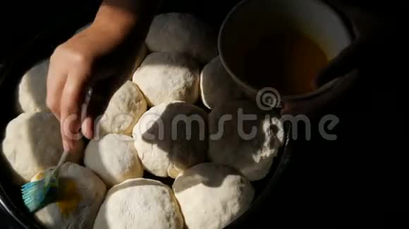 自制烘焙片上一个女面包师用蛋黄将面团中的小球涂上油脂特别厨房视频的预览图