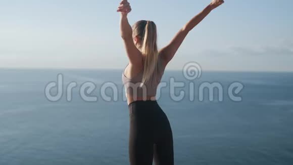 女士在日出时户外健身观海景慢动作视频的预览图