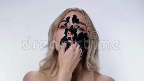 迷人的金发女孩应用化妆面具环境污染黑油视频的预览图