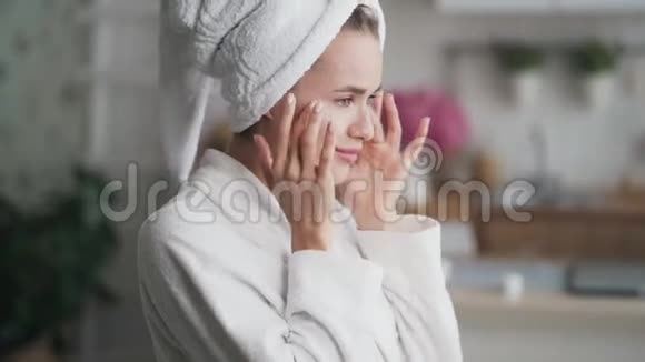 头上有毛巾的女人脸上涂着奶油靠近侧视视频的预览图