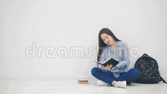 年轻的亚洲女孩参与了读书的过程一边合上书一边拥抱一边坐在莲花的地板上视频的预览图
