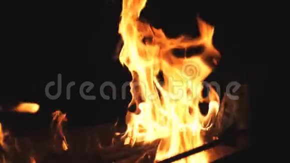 美丽的火焰在夜晚的曼格尔燃烧着的木片升起在黑暗中金属燃烧的火焰视频的预览图
