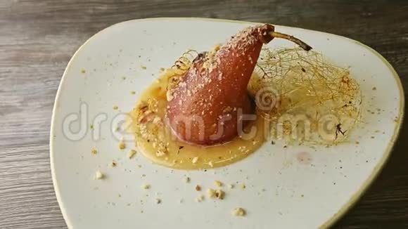 美味的烤梨装饰着焦糖螺旋旋转的盘子视频的预览图