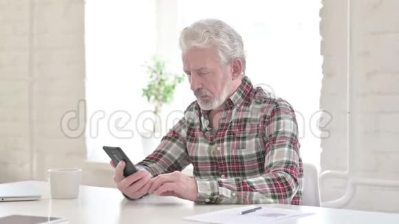 愤怒的休闲老人在智能手机上聊天视频的预览图