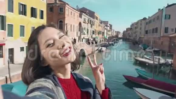 威尼斯的亚洲女人在意大利度假旅行中自拍自画像照片在户外微笑快乐的亚洲女人视频的预览图