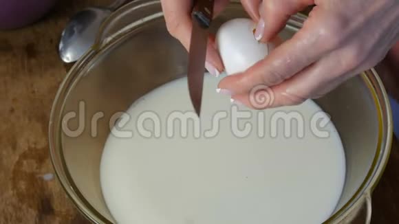 揉制家庭烘焙面团雌性手把生鸡蛋放进一个透明的容器里视频的预览图